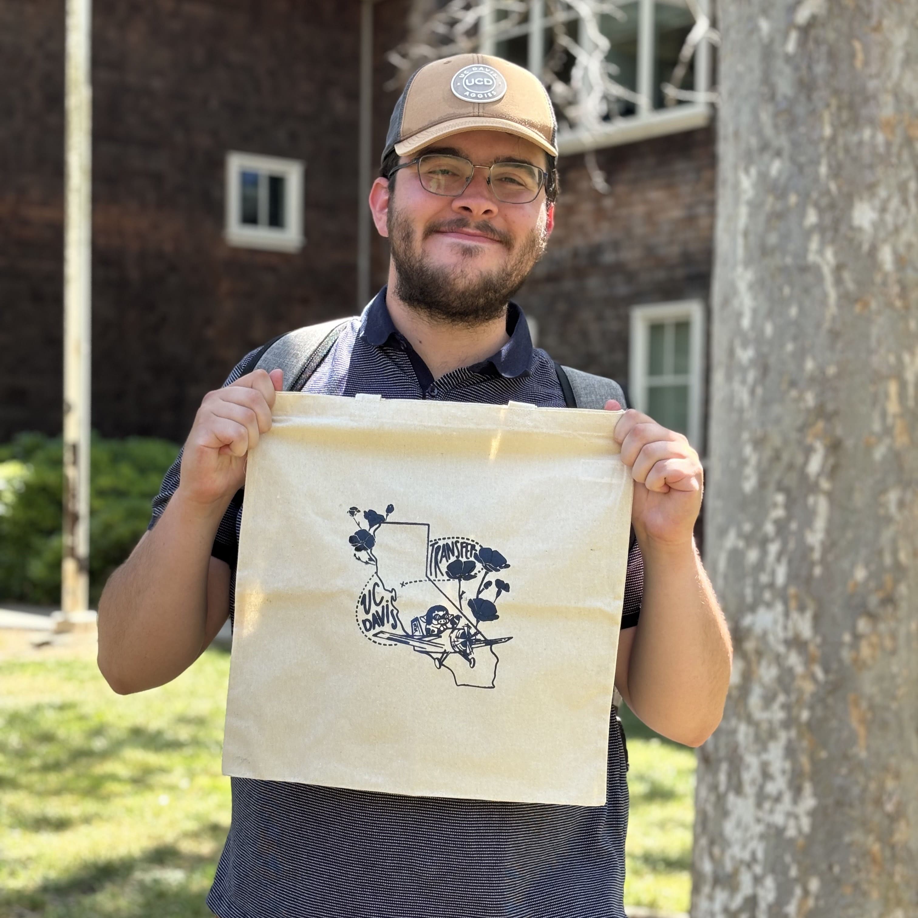 Screen-printed UC Davis transfer tote bag held up on campus